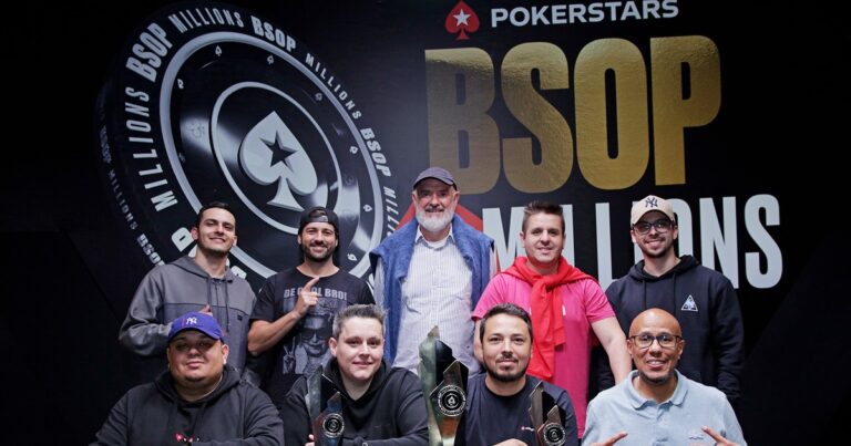 Jogadores da mesa final do Main Event do BSOP Millions 2024 posam com três troféus diante do painel com os logos do BSOP Millions e do PokerStars