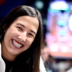 Bárbara Akemi sorri em mesa de torneio ao vivo