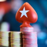 Protetor de cartas vermelho em forma de espada com a estrela do PokerStars sobre pilhas de fichas numa mesa de poker